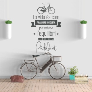 Vinilo frase en catalán la vida es como montar en bicicleta